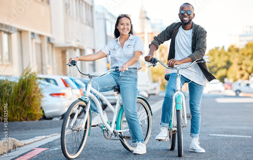 Bike, couple and travel with a black man and asian woman cycling in the city for sightseeing or adventure. Bicycle, carbon footprint and love with a male and female dating in an urban town together © peopleimages.com