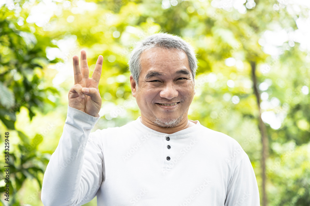 Confident happy smiling old asian man pointing up 3 fingers Confident happy smiling old asian man pointing up 3 fingers