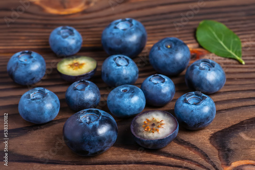 fresh Blueberries with cut in half on wooden background.