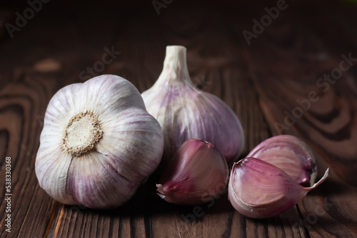 Garlic cloves and bulb on wooden table. Fresh peeled garlics and bulbs.