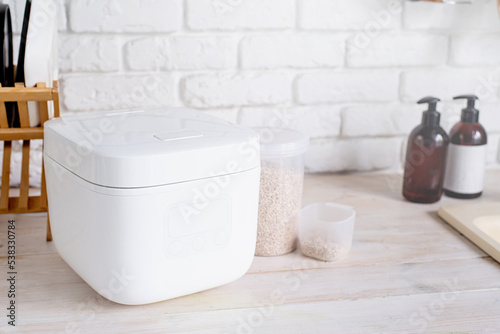 Electric rice cooker on wooden counter-top in the kitchen