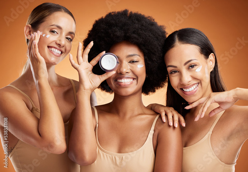 Beauty, skincare and portrait of women with smile in studio with face cream or moisturizer. Happiness, diversity and friends with facial routine for cosmetics, health and wellness by brown background