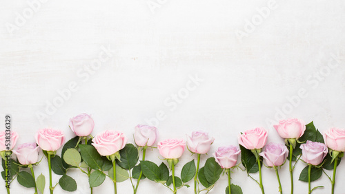 Flowers valentine day composition. Frame made of pink rose on gray background. Flat lay, top view, copy space.