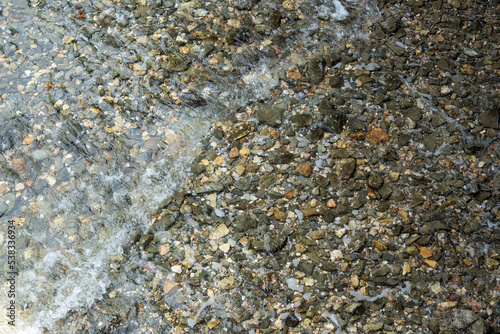 The rocks are under shallow water, so clear that you can see through them.