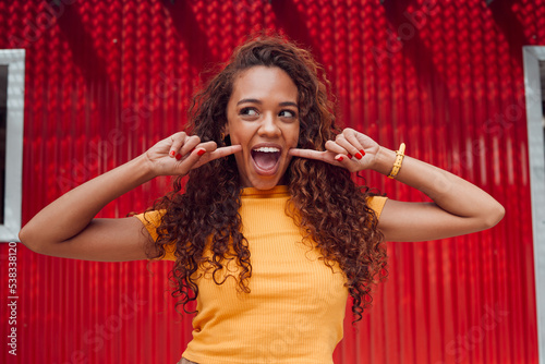 Foto Fashion, summer and woman with smile on red background in city