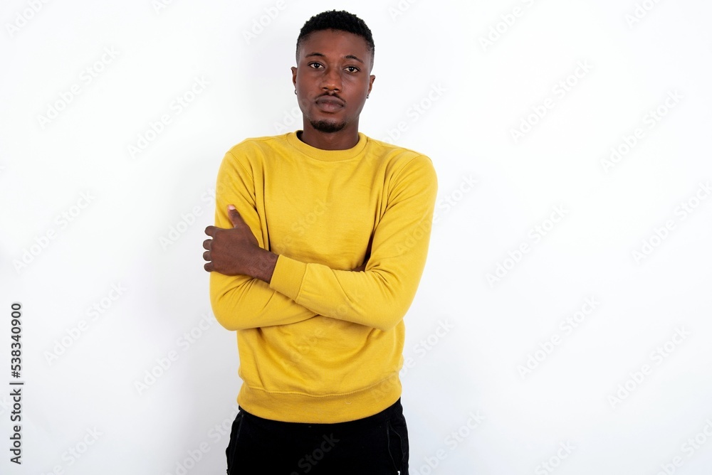 Picture of angry young handsome man wearing yellow sweater over white background looking camera. Picture of angry young handsome man wearing yellow sweater over white background looking camera.