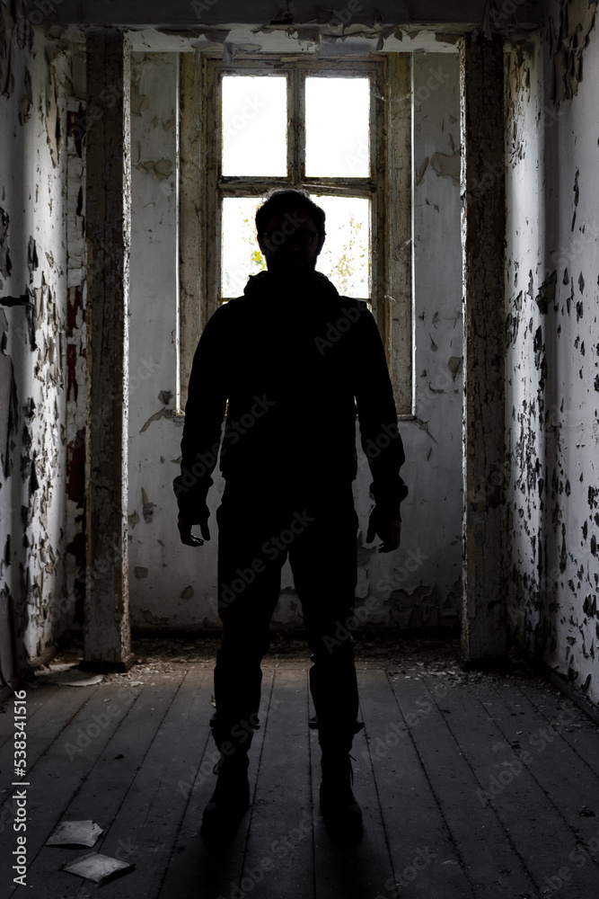 silhouette of determined man in run down room