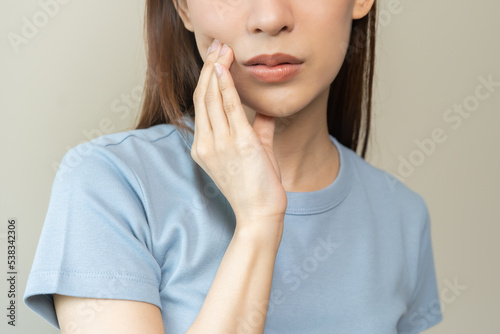 Fotografi Face expression suffering from sensitive teeth and cold, asian young woman, girl feeling hurt, pain touching cheek, mouth with hand