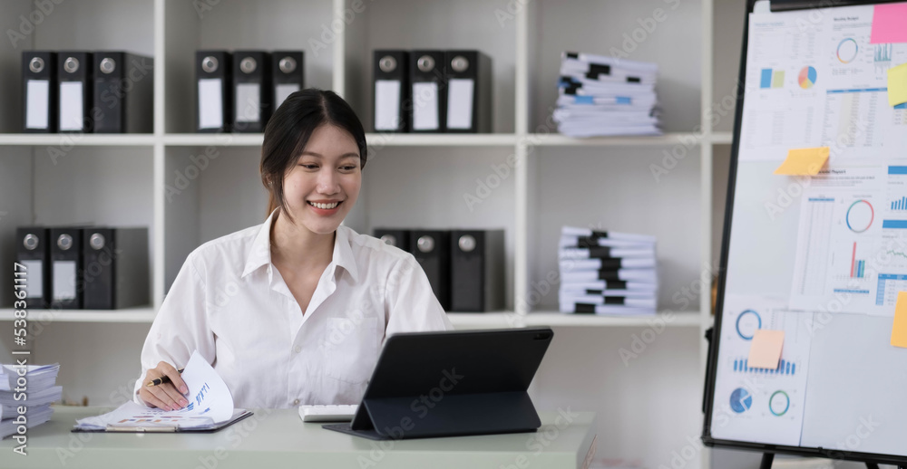 Asian Businesswoman Using laptop computer and working at office with calculator document on desk, doing planning analyzing the financial report, business plan investment, finance analysis concept. Asian Businesswoman Using laptop computer and working at office with calculator document on desk, doing planning analyzing the financial report, business plan investment, finance analysis concept.