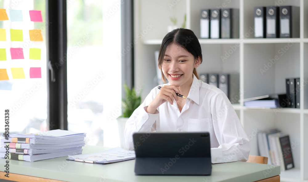 Asian Businesswoman Using laptop computer and working at office with calculator document on desk, doing planning analyzing the financial report, business plan investment, finance analysis concept. Asian Businesswoman Using laptop computer and working at office with calculator document on desk, doing planning analyzing the financial report, business plan investment, finance analysis concept.