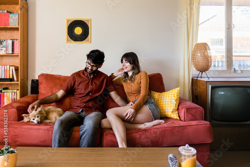 couple at home in living room with dog on sofa