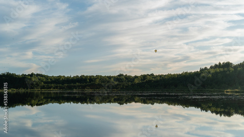 float over the lake and are reflected in the water.