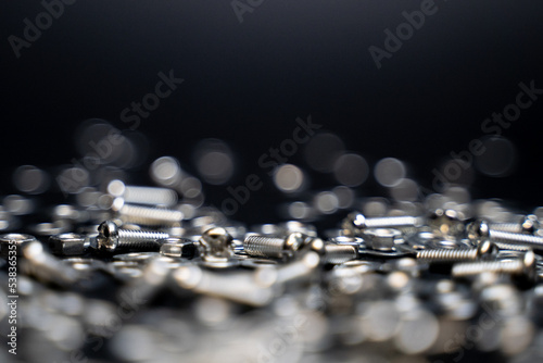 Close up crafts of bolts, screws, nuts, washers, mechanical parts falling and bouncing in slow motion. black background. precision work. Work as a carpenter. Joinery and construction work.