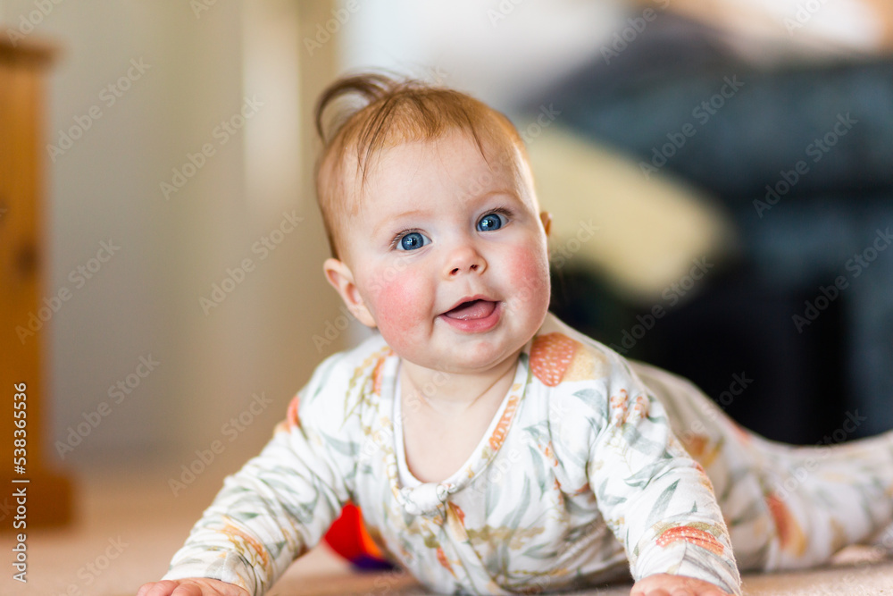 © Austockphoto - happy five month old baby girl with blue eyes learning to crawl on floor © Austockphoto - happy five month old baby girl with blue eyes learning to crawl on floor
