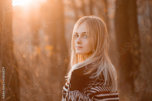 Portrait of young blonde woman outdoors in autumn. Turn around