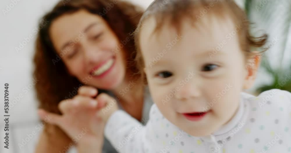Happy, mother and baby playing on bed holding hands in joyful fun bonding time together with smile at home. Mom and little child face smiling in happiness for playful funny moment relaxing in bedroom Happy, mother and baby playing on bed holding hands in joyful fun bonding time together with smile at home. Mom and little child face smiling in happiness for playful funny moment relaxing in bedroom