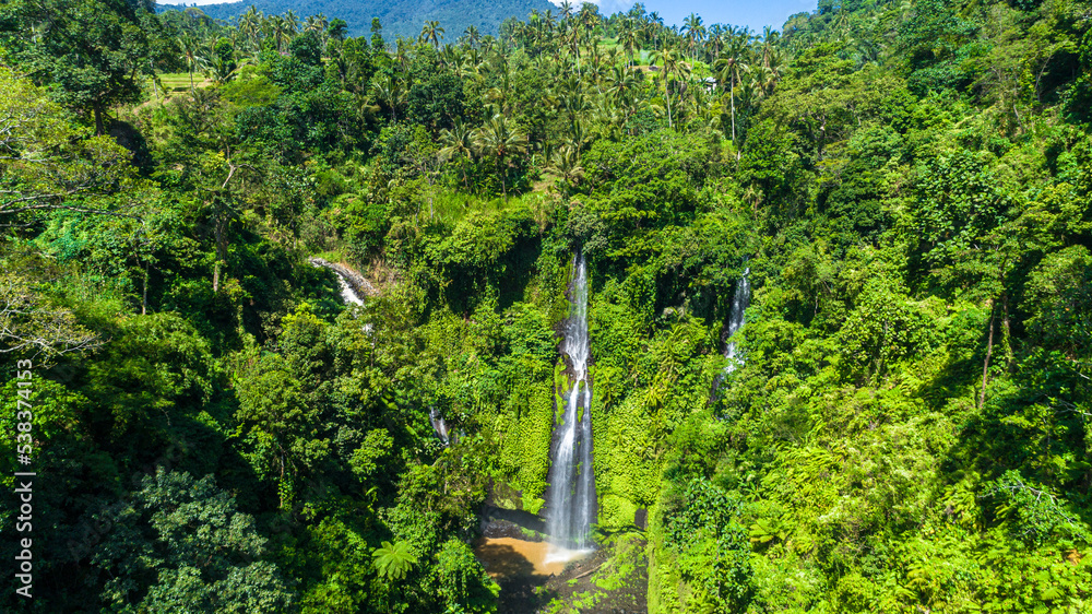 Beautiful tropical waterfall Bali Indonesia in forest at sunny day aerial view