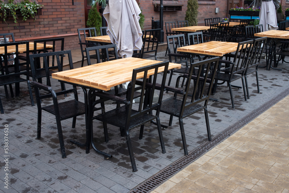 Cafe table and chairs on the street KALiningrad. Wooden table with black chairs