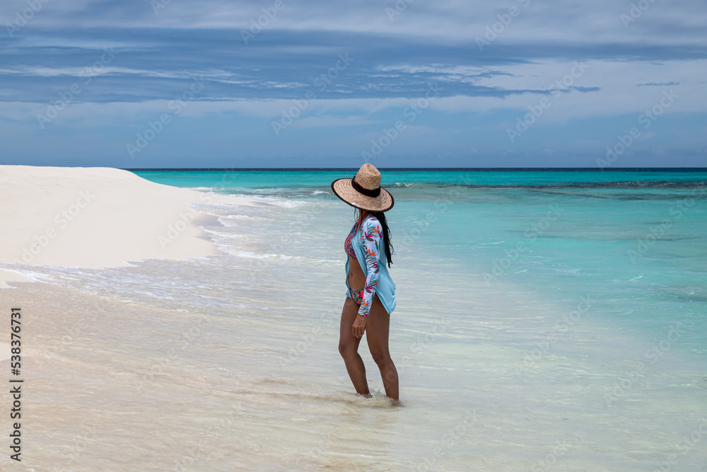 Cayo de Agua (Los Roques Archipelago), Venezuela:: a young woman in the white beach with crystalline water.