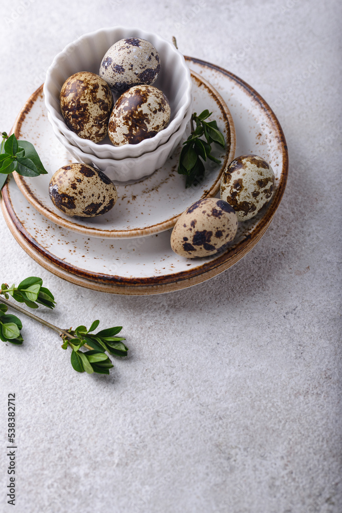Bowl with quail eggs on light background