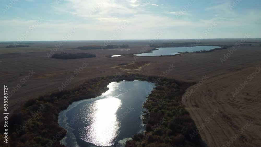 Intact wetlands in a rural area of Saskatchewan, Canada, surround by farmed fields. Late fall. Intact wetlands in a rural area of Saskatchewan, Canada, surround by farmed fields. Late fall.