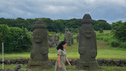 Mujer caminando entre estatuas de roca en la isla de Jeju, Corea del Sur