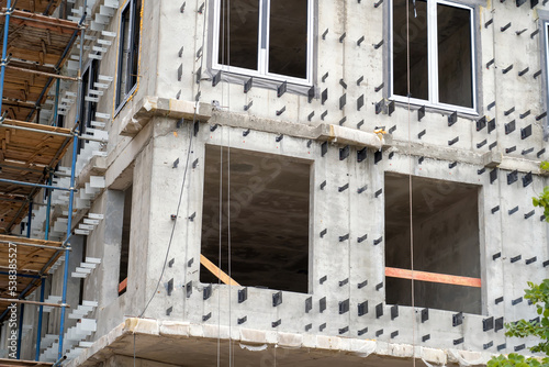 Preparation of walls for Insulation with mineral wool and installation of a hinged system of a ventilated facade. Concrete wall background with attached aluminum holders or brackets for mineral wool photo