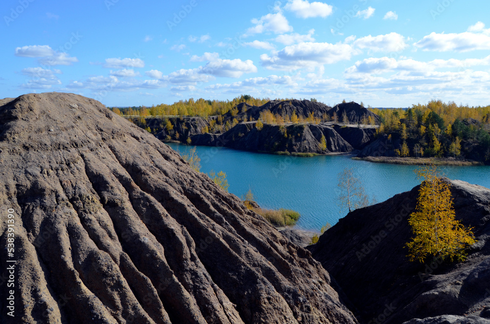Autumn in the mountains. Stunning autumnal landscape with a coal mountain peak in the foreground and a beautiful blue lake and colorful trees around it. Autumn in the mountains. Stunning autumnal landscape with a coal mountain peak in the foreground and a beautiful blue lake and colorful trees around it.