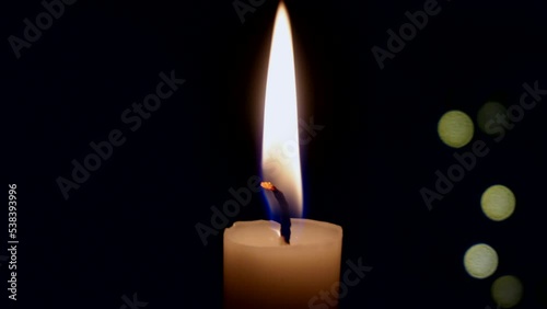 A single candle burns. Close-up of a white wax candle in the dark. Tragedy. Memory. War and death. Fire in the temple on the altar. Religion. Life without electricity. Energy Crisis on Earth. memory 