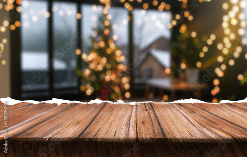 mock up di tavolo in legno ideale per inserimento prodotti, su sfondo natalizio con alberi sfocati e luci di natale photo