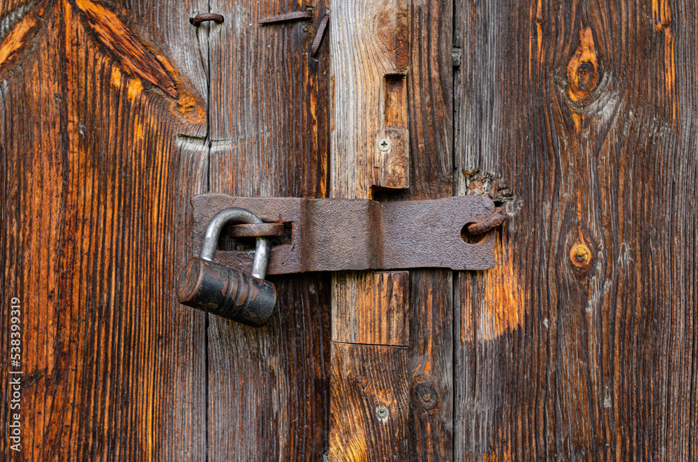 Lock on an old wooden door with rusty inserts Lock on an old wooden door with rusty inserts