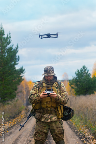 The mercenary launches a reconnaissance drone. Vertical photo. photo