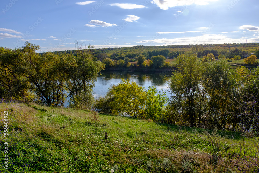 autumn green meadow on the background of the river landscape