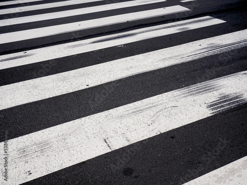 The trace of a sharp braking of a tire on the white pedestrian crossing along a road