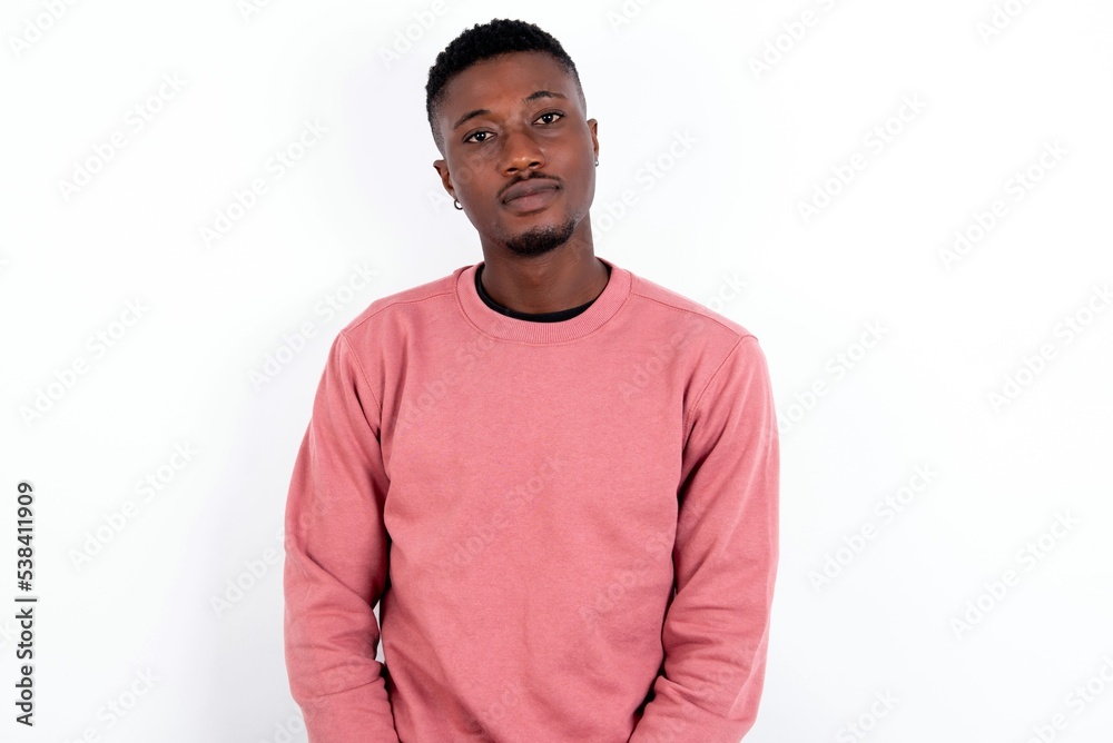 Happy young handsome man wearing pink sweater over white background looking at camera with charming cute smile. Happy young handsome man wearing pink sweater over white background looking at camera with charming cute smile.