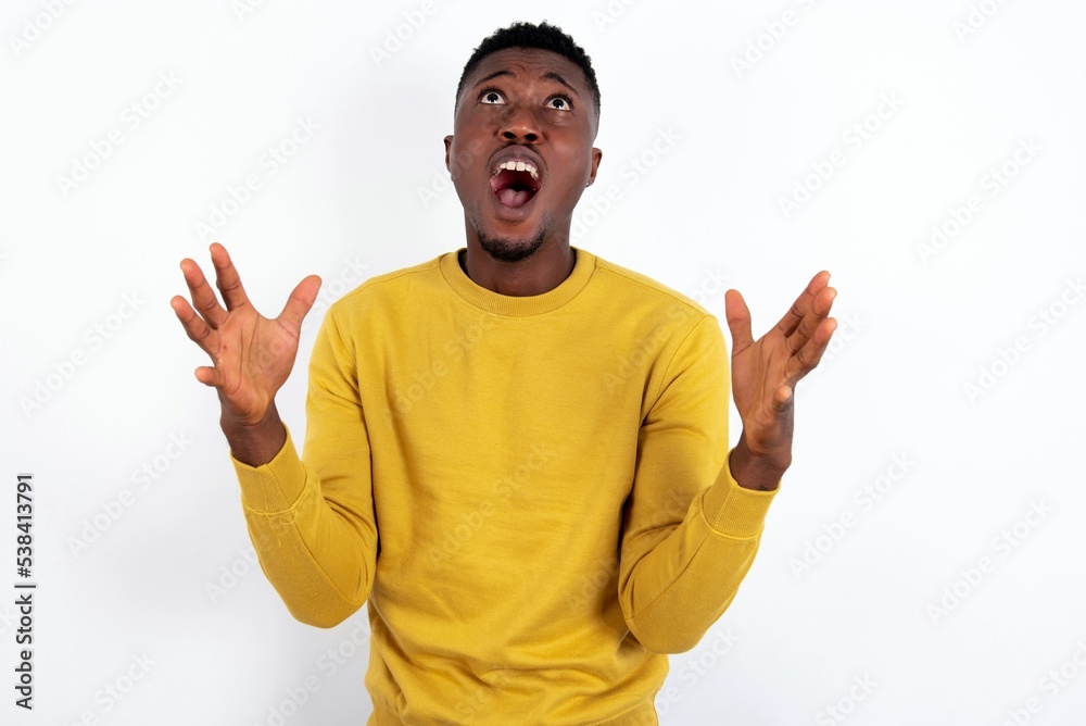 young handsome man wearing yellow sweater over white background crying and screaming. Human emotions, facial expression concept. Screaming, hate, rage. young handsome man wearing yellow sweater over white background crying and screaming. Human emotions, facial expression concept. Screaming, hate, rage.