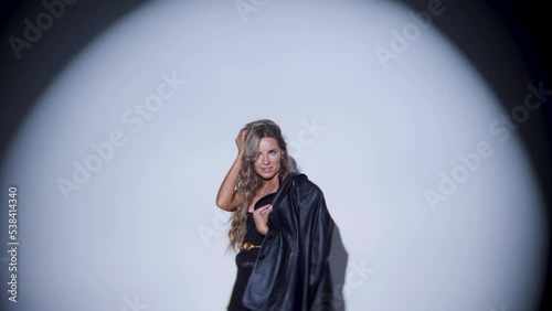 photographing a portrait of a beautiful sexy woman in the studio using a gabo mask and a white cyclorama. woman photographer on the silhouette takes pictures with a digital camera