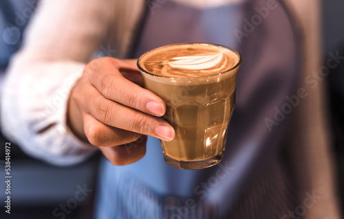 Close up Barista hand holding glass of driping coffee in coffeeshop, Coffee Barista Concept