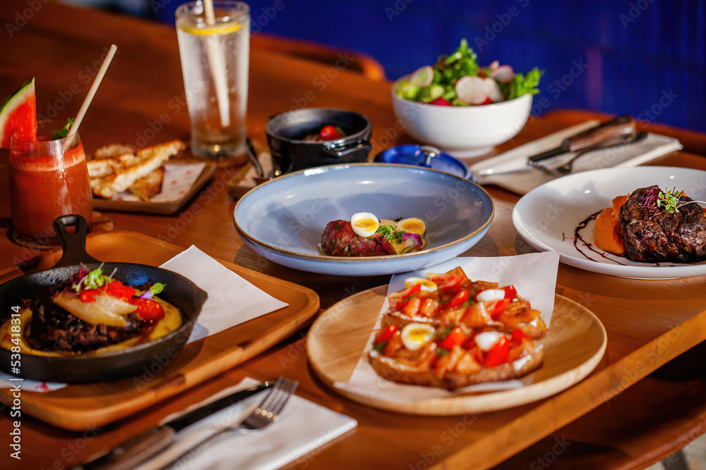 Table full of delicious food, tasty meat dishes and salmon toast