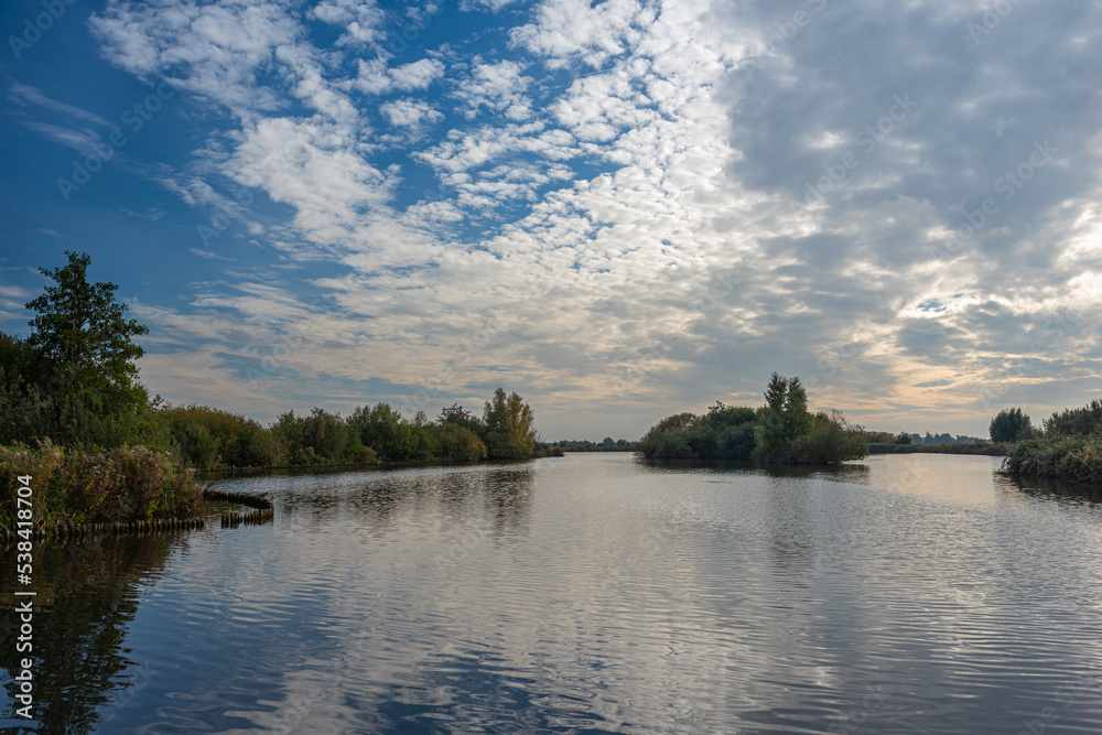 Altocumulus clouds are reflected in the calm water of recreation area Reeuwijkse Hout, close to Gouda, Holland. Altocumulus clouds are reflected in the calm water of recreation area Reeuwijkse Hout, close to Gouda, Holland.