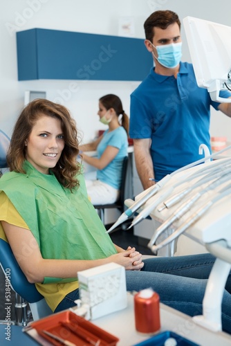 Female patient sitting in dentists chair, waiting for treatment.