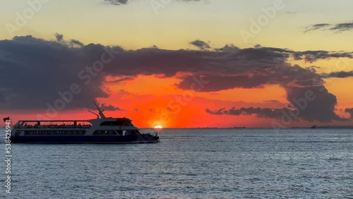 Silhouette of an in city passenger ship sailing across the stunning sunset over the Marmara Sea. Princes Islands liner motorboat underway at sunset
