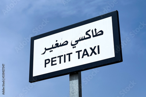 Small taxi signpost with blue sky in the background
