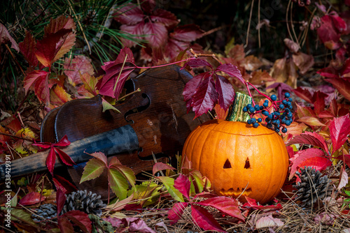 End of Summer.  Spooky Jack-o’-lantern, Jack, with a fiddle and changing leaves.  