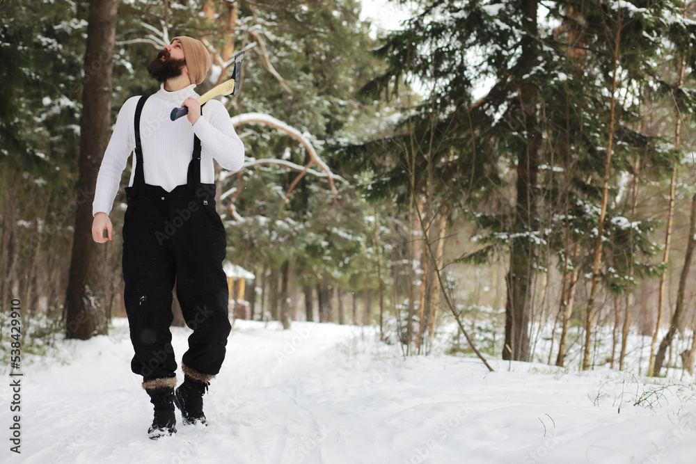Outdoor portrait of handsome man in coat and scurf. Bearded man in the winter woods.