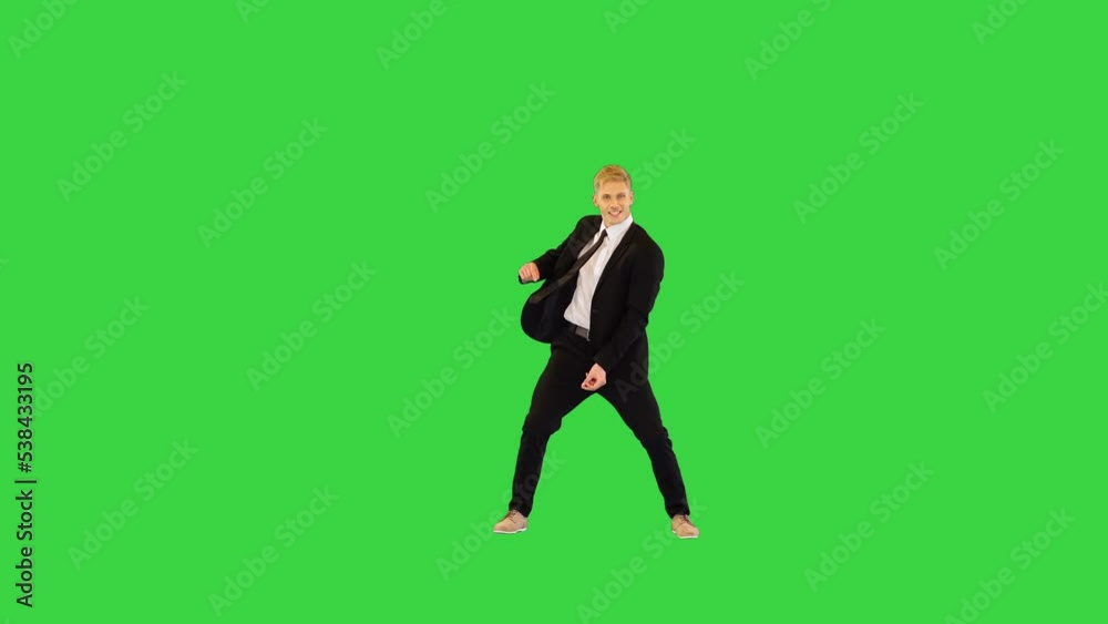 Smart guy in black office suit dances performing different elements on a Green Screen, Chroma Key.