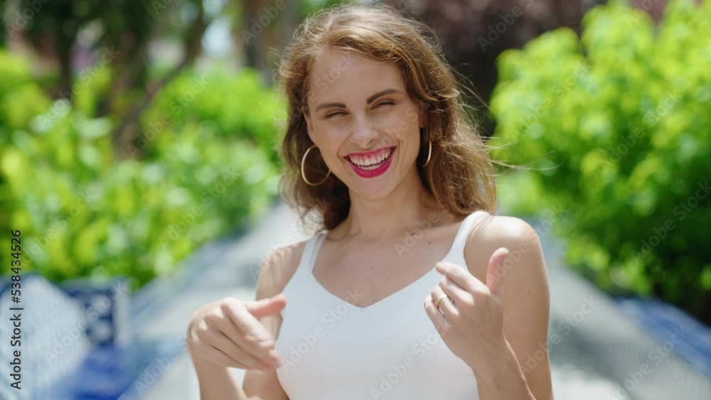 Young beautiful hispanic woman smiling confident doing coming gesture with hand at park Young beautiful hispanic woman smiling confident doing coming gesture with hand at park