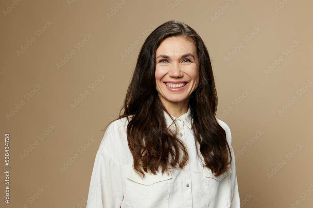 portrait of a beautiful attractive woman with long well-groomed hair standing in a white shirt and smiling pleasantly looking at the camera portrait of a beautiful attractive woman with long well-groomed hair standing in a white shirt and smiling pleasantly looking at the camera