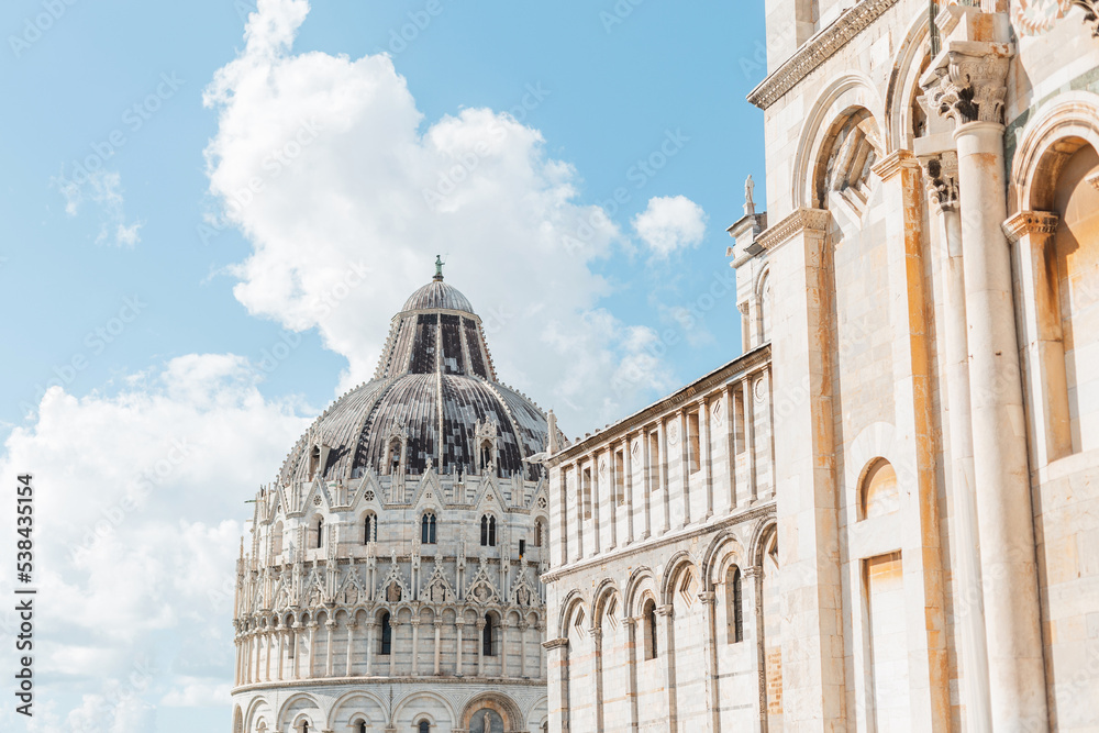 Beautiful vintage architecture on a blue cloudy sky in an ancient European town. Travelling in Pisa, Italy. Beautiful facade of a cathedral