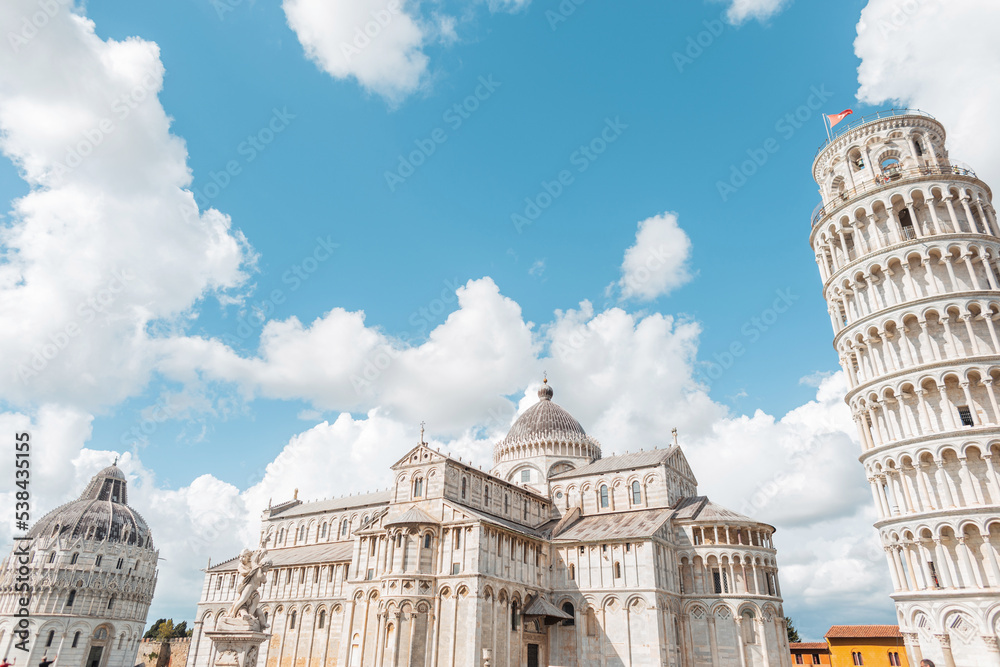 Beautiful expensive historical architecture with towers, churches, and cathedral on a blue cloudy sky in the cozy European town of Pisa, Italy